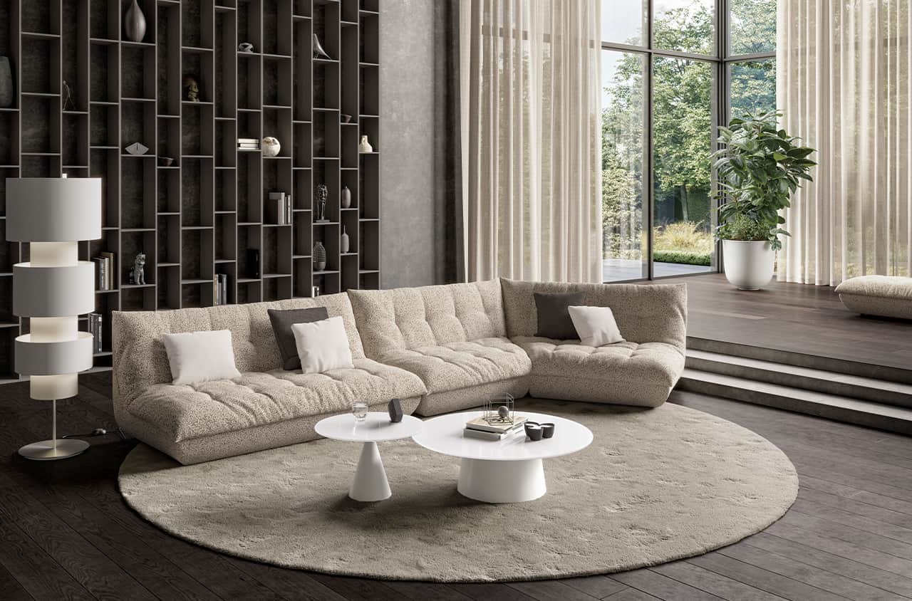 Beiges Ecksofa mit weicher, strukturierter Oberfläche, tiefen Sitzflächen und fließenden Formen in großzügiger Wohnumgebung.